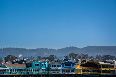 Houses and buildings against clear blue sky