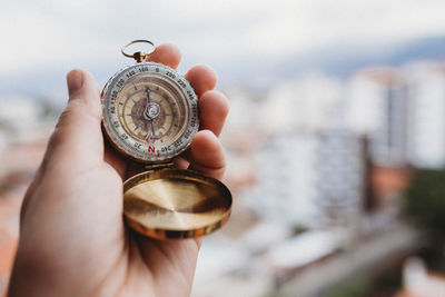 One hand holding a compass