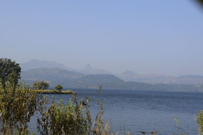 Scenic view of lake against clear blue sky