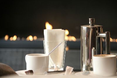 Close-up of coffee cup on table against fireplace 