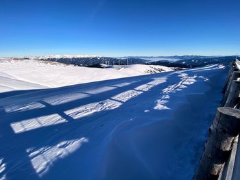 Aerial view of snowcapped mountain against blue sky