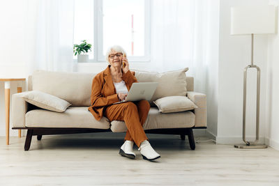 Woman sitting on sofa at home