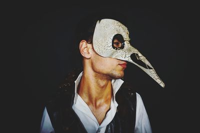 Man wearing mask over black background