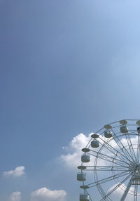 Low angle view of ferris wheel against blue sky