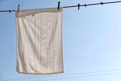 Low angle view of clothes hanging on clothesline against clear sky