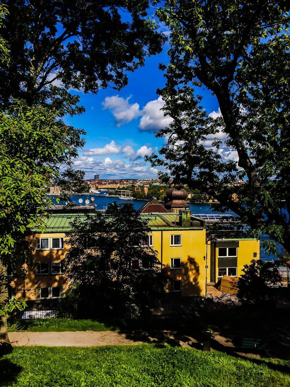 building exterior, tree, architecture, built structure, sky, house, cloud - sky, growth, residential structure, green color, residential building, cloud, water, nature, plant, grass, city, lawn, day, outdoors