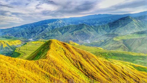 Scenic view of mountains against cloudy sky