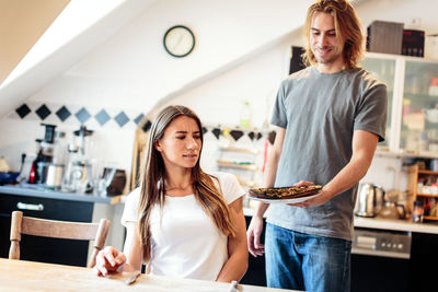 Happy young woman standing by food