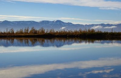 Scenic view of lake by mountains against sky