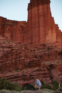 Camper zips up her tent under the titan at fisher towers campsite