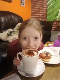 Portrait of smiling girl sitting at home