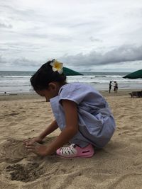 Boy on beach against sky