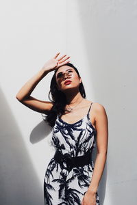 Young woman standing against wall