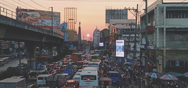 Vehicles on street amidst buildings in city against sky
