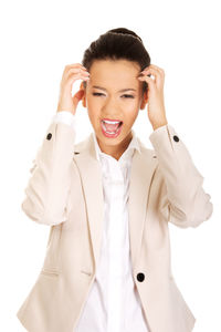 Close-up of businesswoman screaming while standing against white background