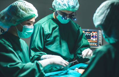 Surgeons performing surgery in operating theater