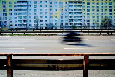 Blurred motion of building by road in city