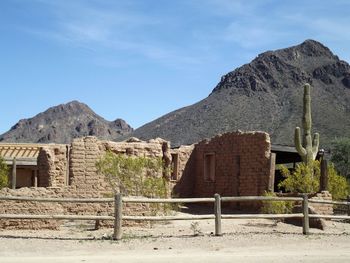 Old building by mountains against sky