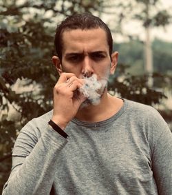 Portrait of young man smoking cigarette