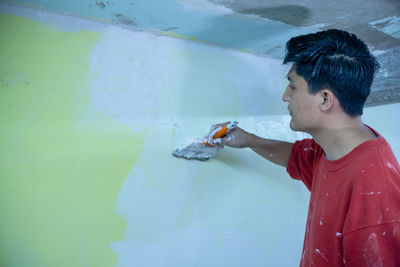 A young man holding paint brush