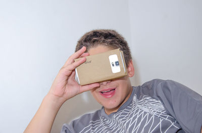 Boy watching virtual reality against white background