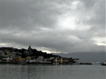 Buildings in city against cloudy sky