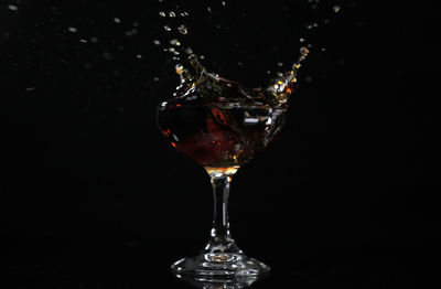 Close-up of wine glass against black background