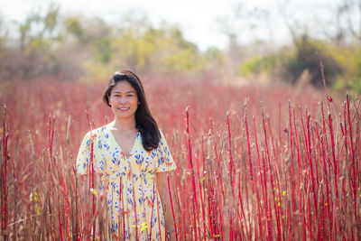 Portrait of smiling young woman standing on field