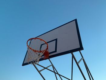 Low angle view of basketball hoop against blue sky