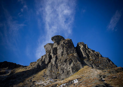 Low angle view of mountain against blue sky