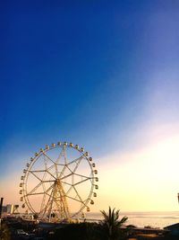 Ferries wheel against calm sea and blue sky