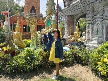 Man standing by statue outside temple