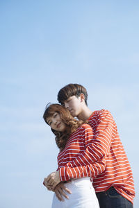 Low angle view of couple standing against sky