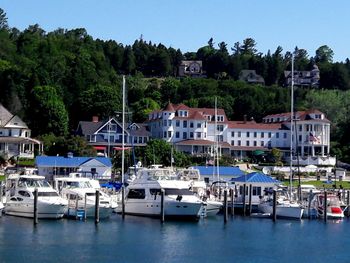 Yachts moored in sea against buildings at town