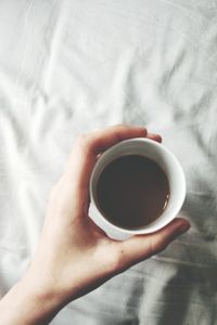 Close-up of hand holding coffee cup