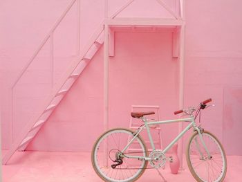 Bicycle leaning on wall of building