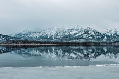 The hopfensee with the allgäu alps in winter. germany.