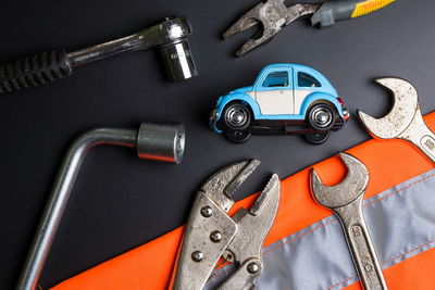 High angle view of toy car with hand tools on table