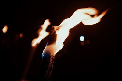 Close-up of lit candle against black background