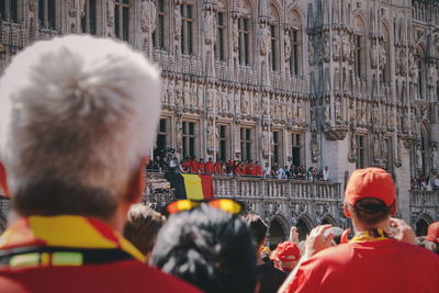 Rear view of people on street against buildings in city