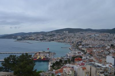 High angle view of city by sea against sky