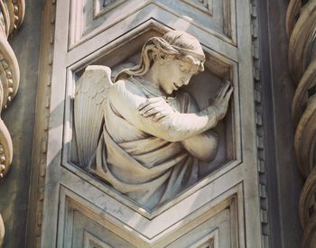 Low angle view of statue against historic building