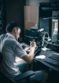 A young man repairs the engine steering wheel on a joystick.