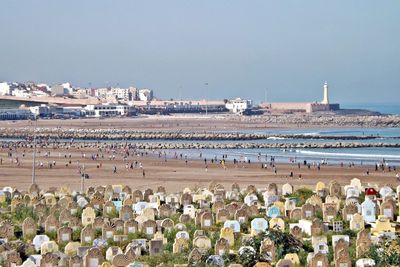 Crowd at beach against sky