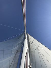 Low angle view of sailboat against clear blue sky