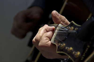 Midsection of guitarist playing guitar