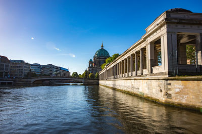 Arch bridge over river against buildings in city