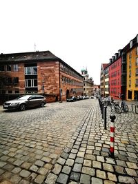 Cobblestone street amidst buildings against sky