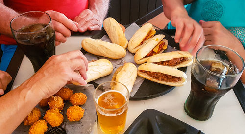 Midsection of people eating food on table