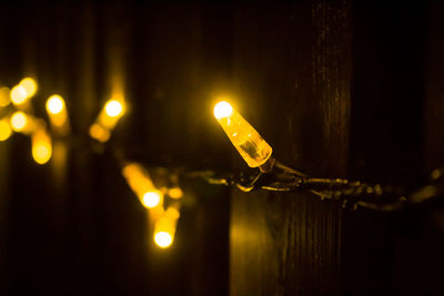 Close-up of light bulb hanging at night